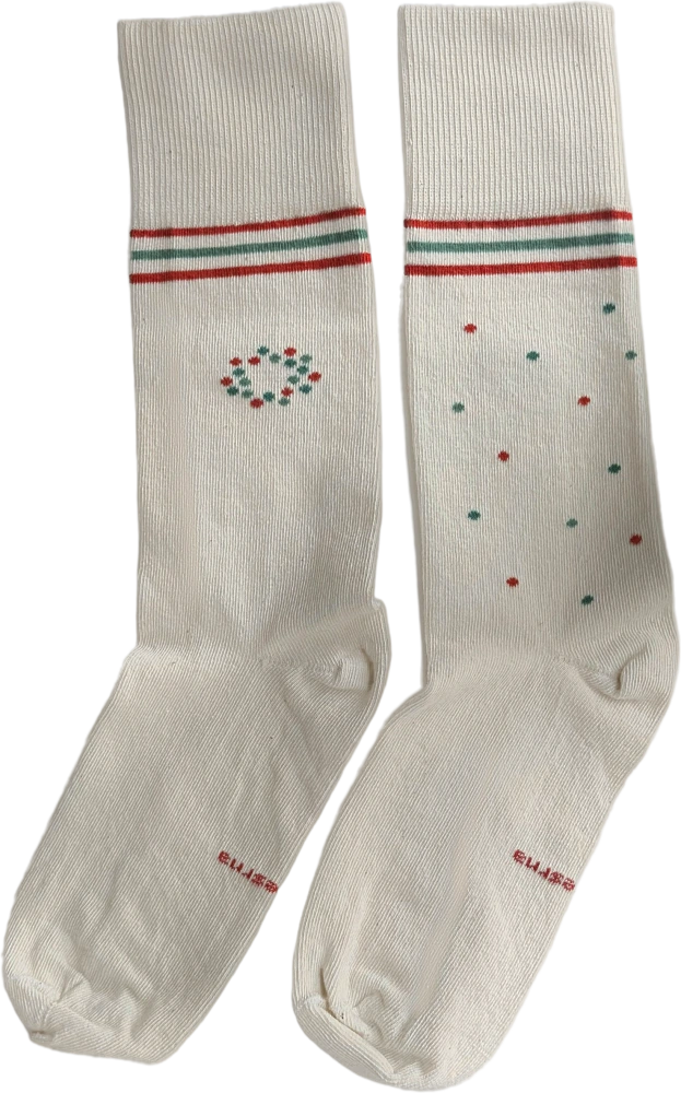 The 2026 Care Socks: two cream socks with red and teal stripes. One has a circle of dots, the other has dots scattered down the leg.