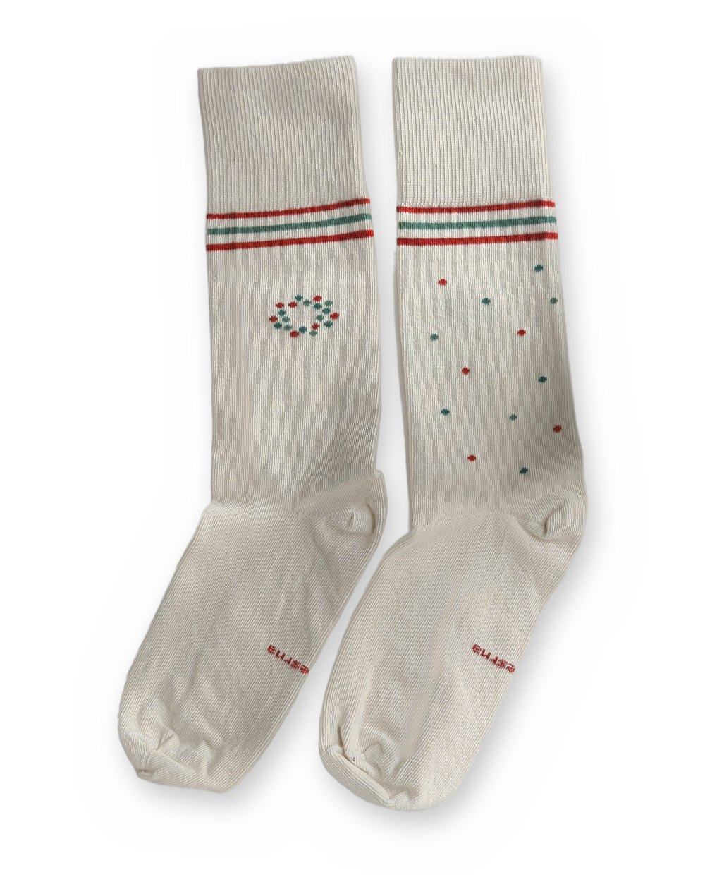 A pair of Care Socks side by side: a circle of red and teal dots on one sock, scattered dots on the other.